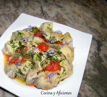 Tecnica de cocina: alcachofas a la sal presentadas con flor de tomate y hierbas, receta paso a paso