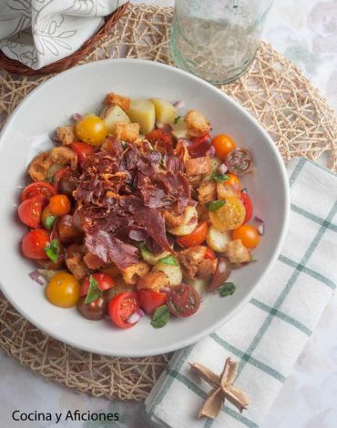 Ensalada de tomates con tostones de pan y crujiente de jamón, llenita de color y de sabor.