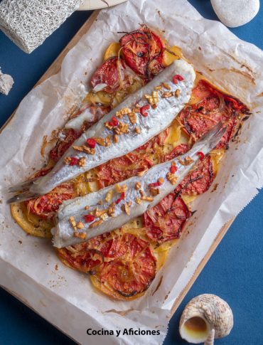 Bacaladillas sobre un crujiente de patatas, tomate y cebolla , receta sana y sencilla