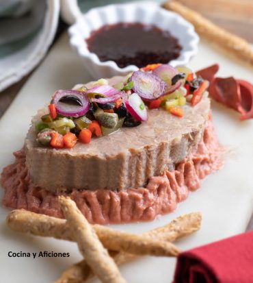Pate/rillette de carne de cerdo sobre humus de berenjena, un plato de fiesta